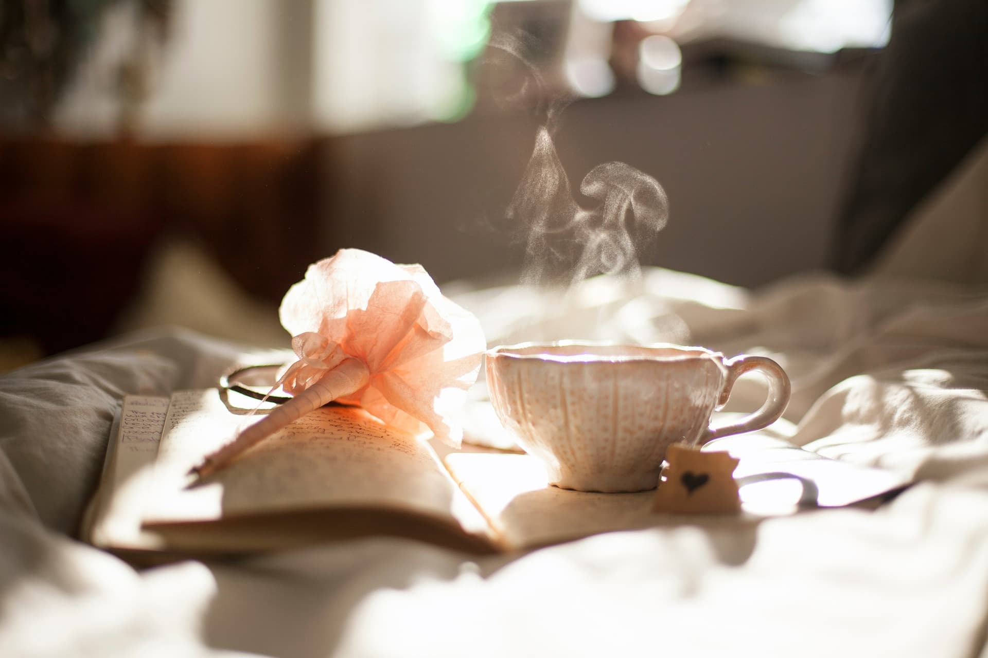 Teetasse und Tagebuch in warmem Licht